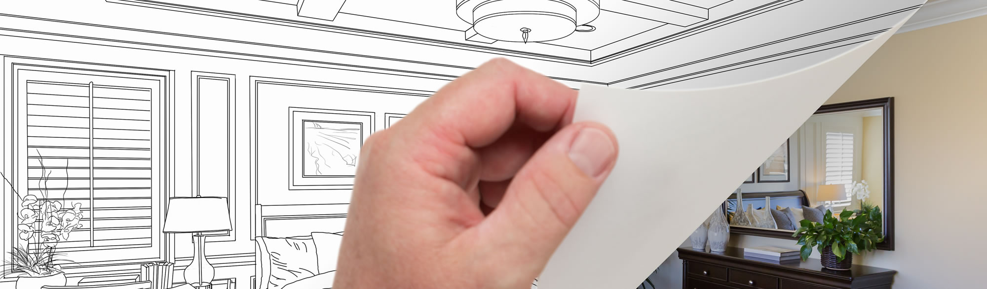 Photo of a hand pulling back a blueprint to reveal a finished project